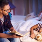 Image of a father reading his child a bedtime story.