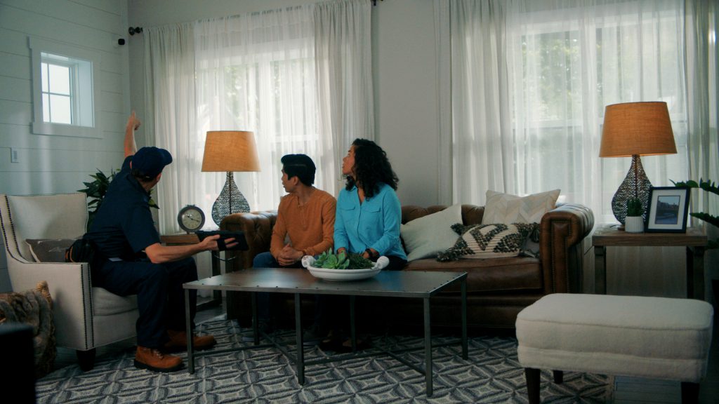 Professional installer showing customers their newly installed Guardian Protection indoor camera