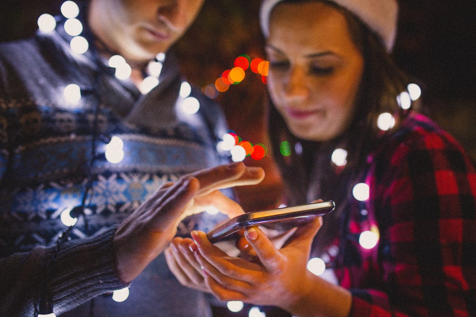 Couple celebrating holidays and looking at phone