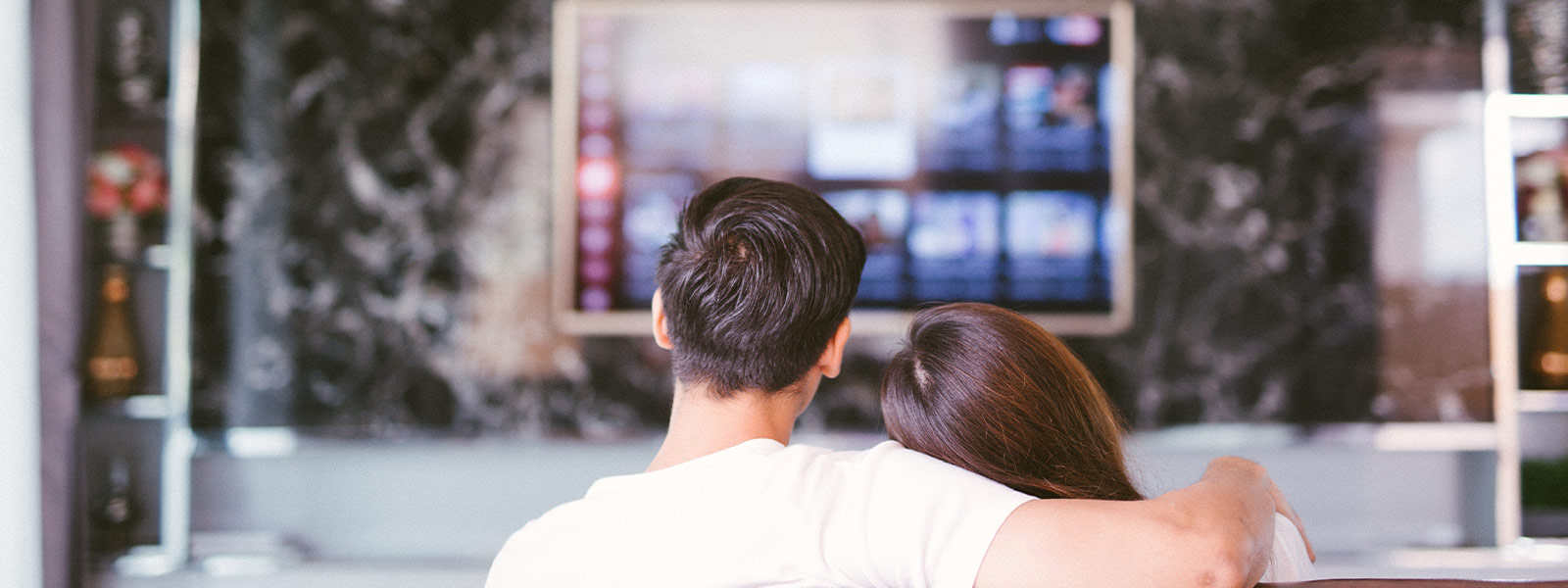 A couple watching TV with their home entertainment system