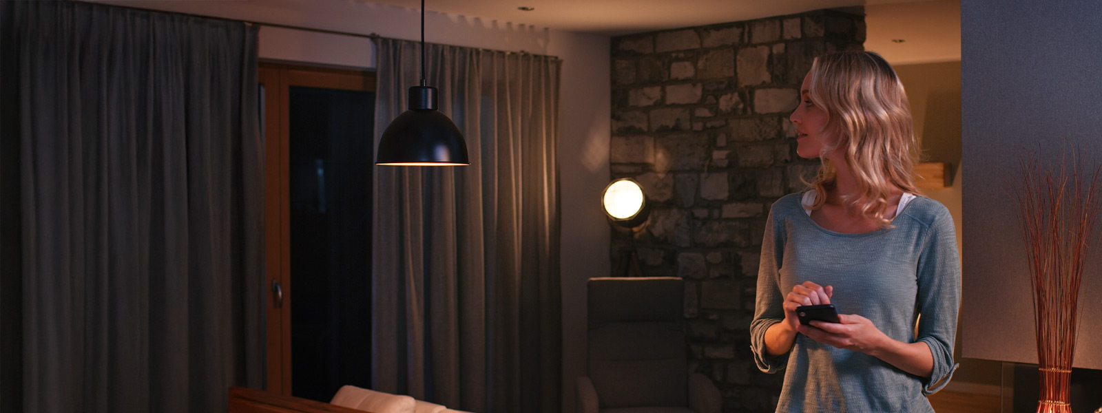 Woman using her smart phone to control her Guardian security system with home automation