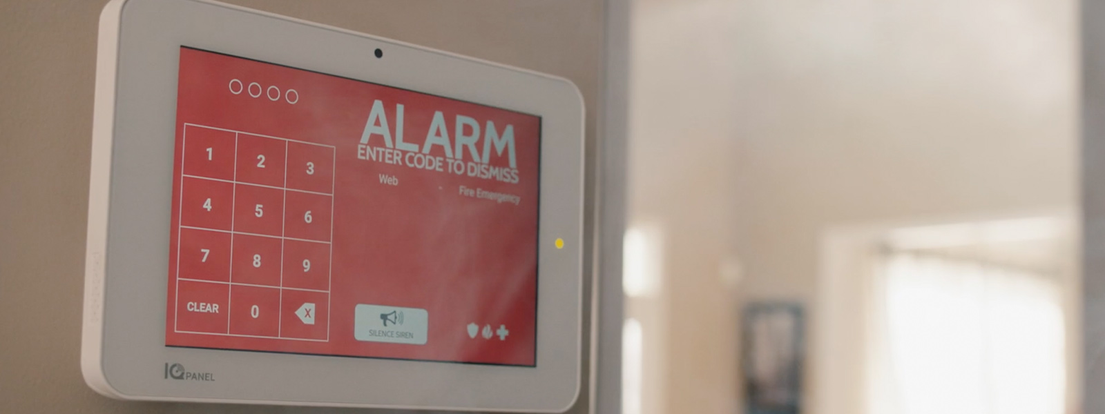 Guardian Protection IQ4 panel on wall alerting an alarm has been triggered