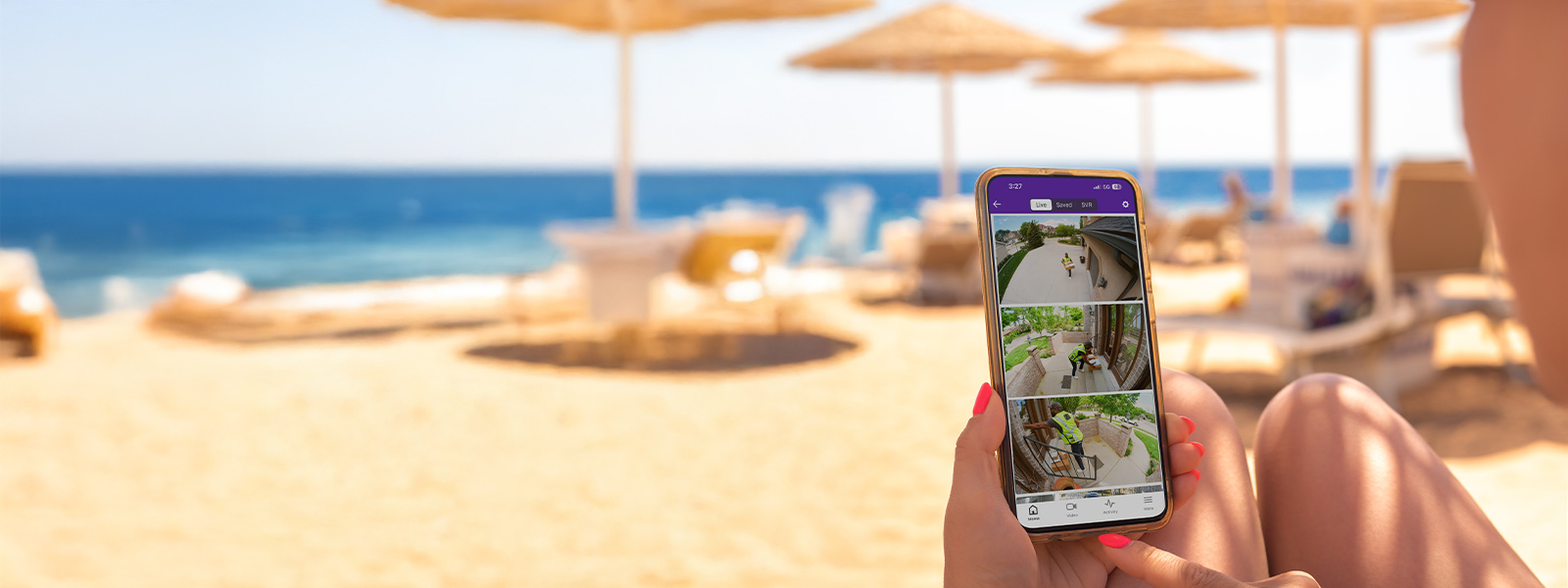 Woman on a beach checking live video feed from Guardian app
