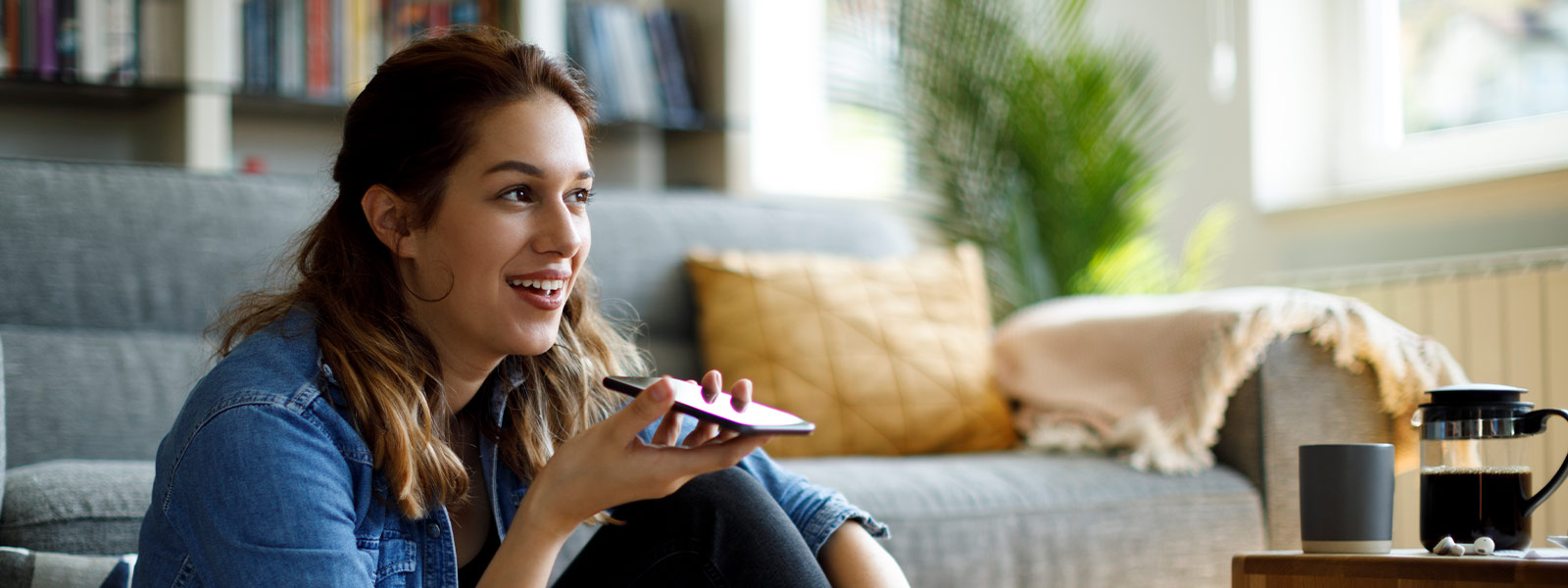 Woman using her smartphone for her outdoor camera's two-way voice feature