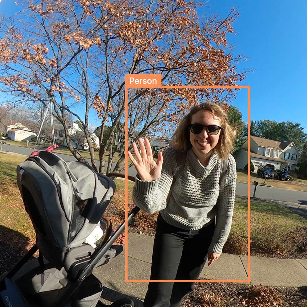 Woman with stroller waving at Video Doorbell Camera and video analytics showing that a person has been captured.
