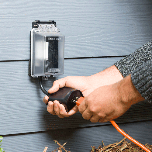 A person plugging a cord in Guardian Protection's outdoor smart plug