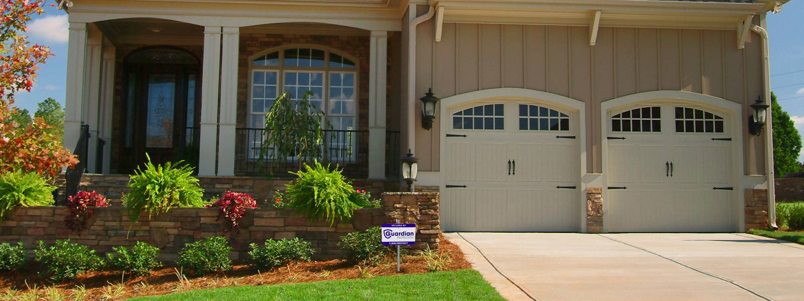 A house with a Guardian Protection yard sign in the front yard