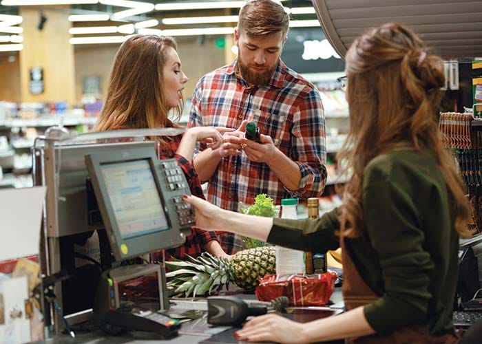 Two people checking out at a convenience store