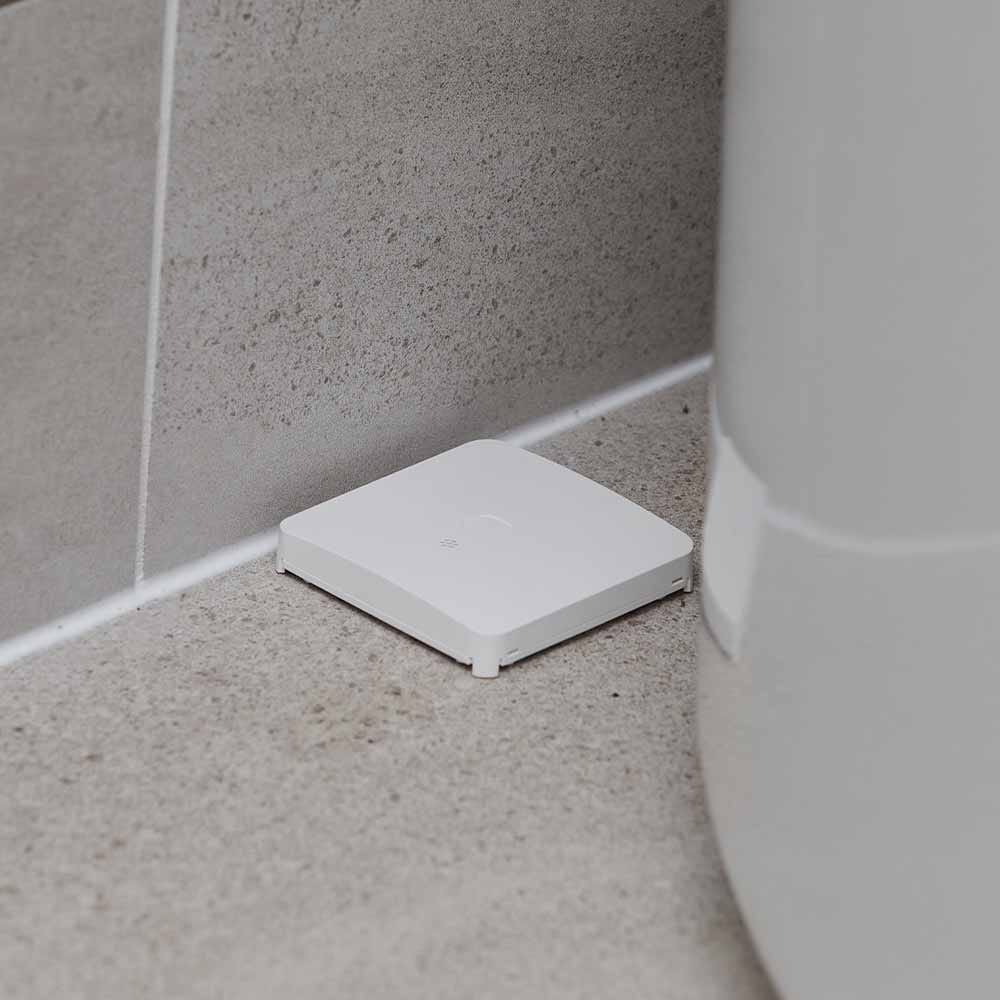 Guardian Protection's Water and Freeze Sensor placed behind a home's water heater